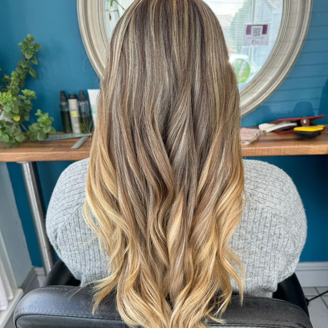 Long layered balayage melting from brunette into golden blonde ends